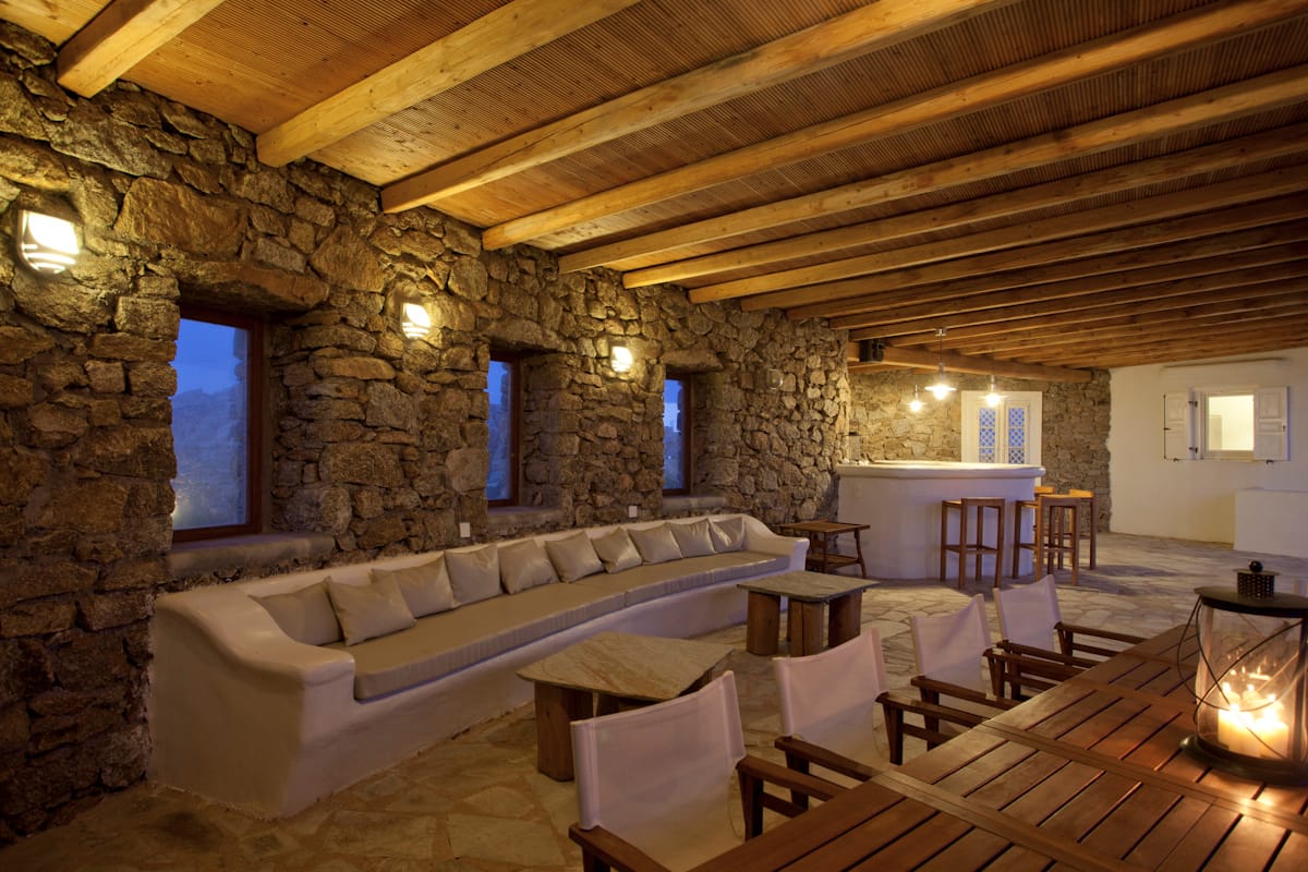 A stone-walled lounge with a long built-in sofa