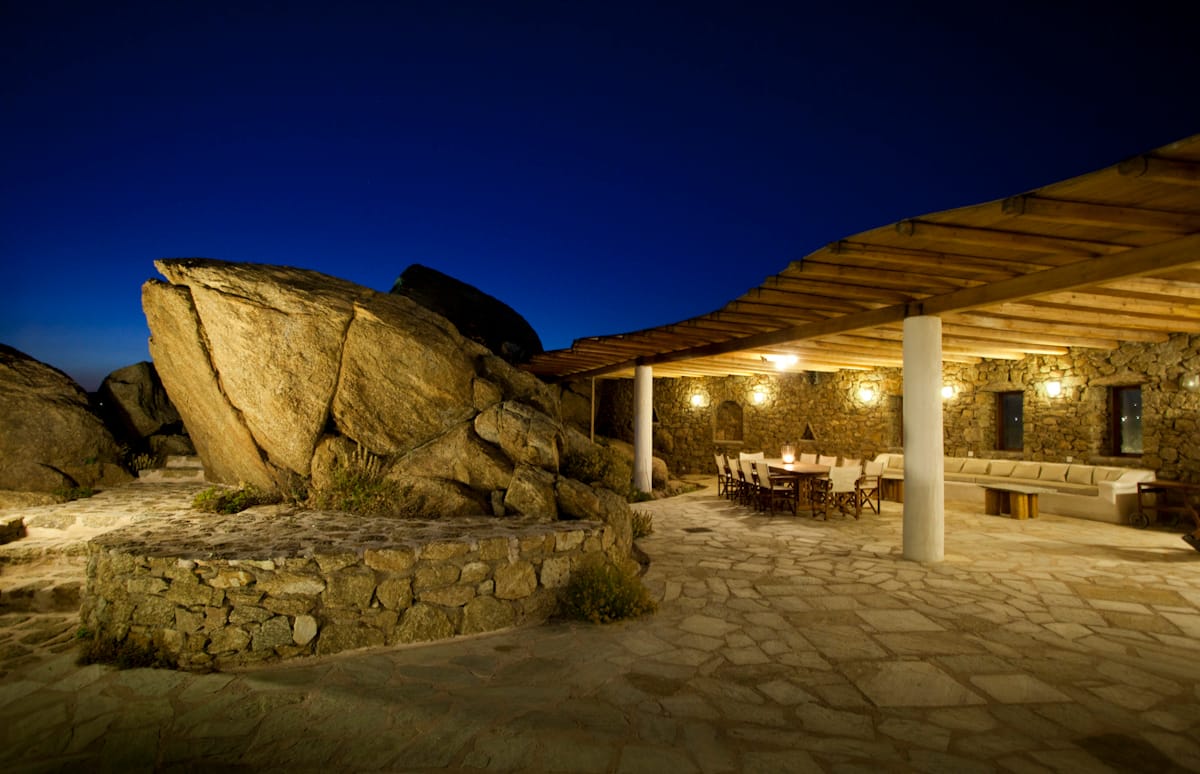The pergola at night, lit up beside the boulders