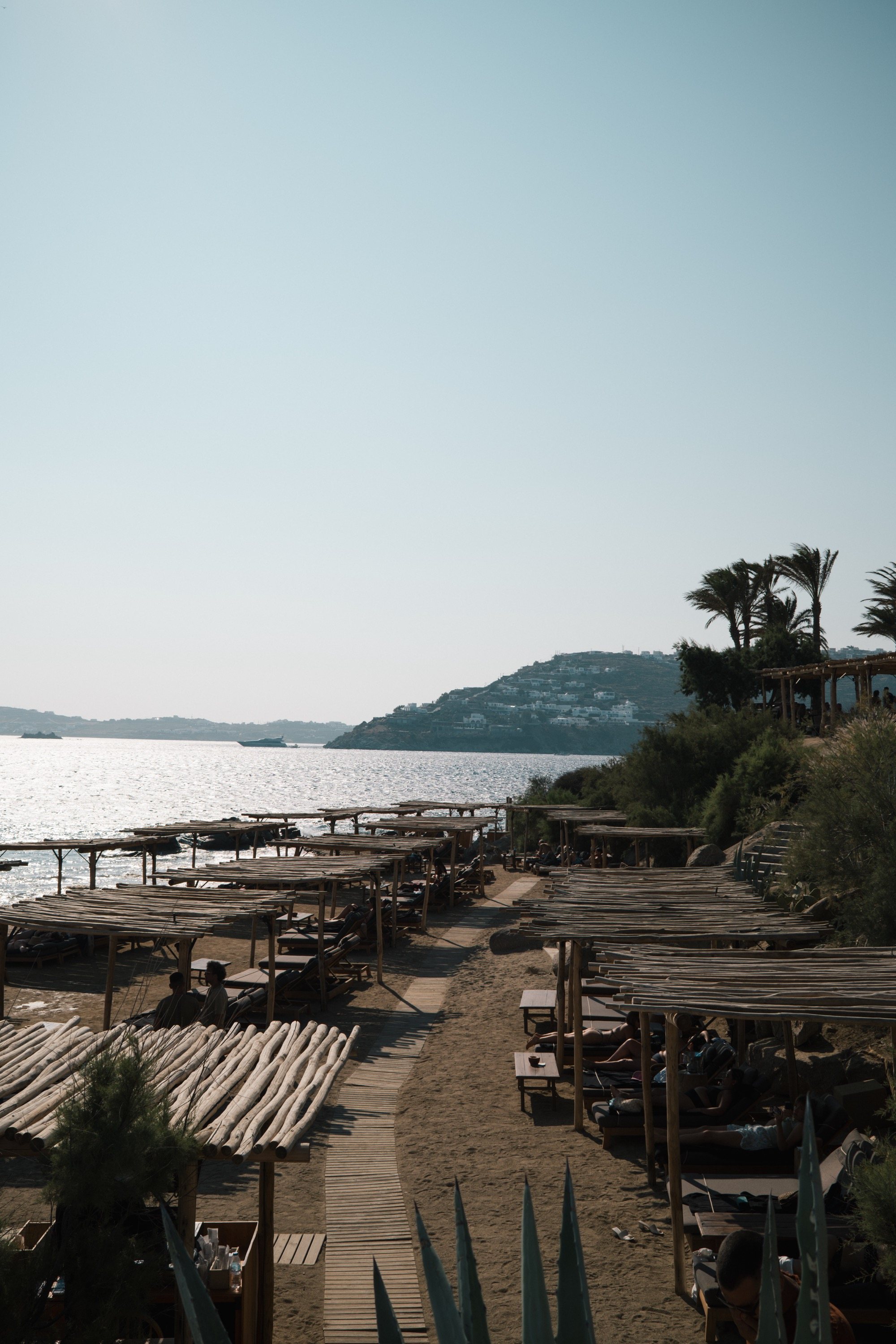 A beach club on Mykonos, shaded loungers running down to the water
