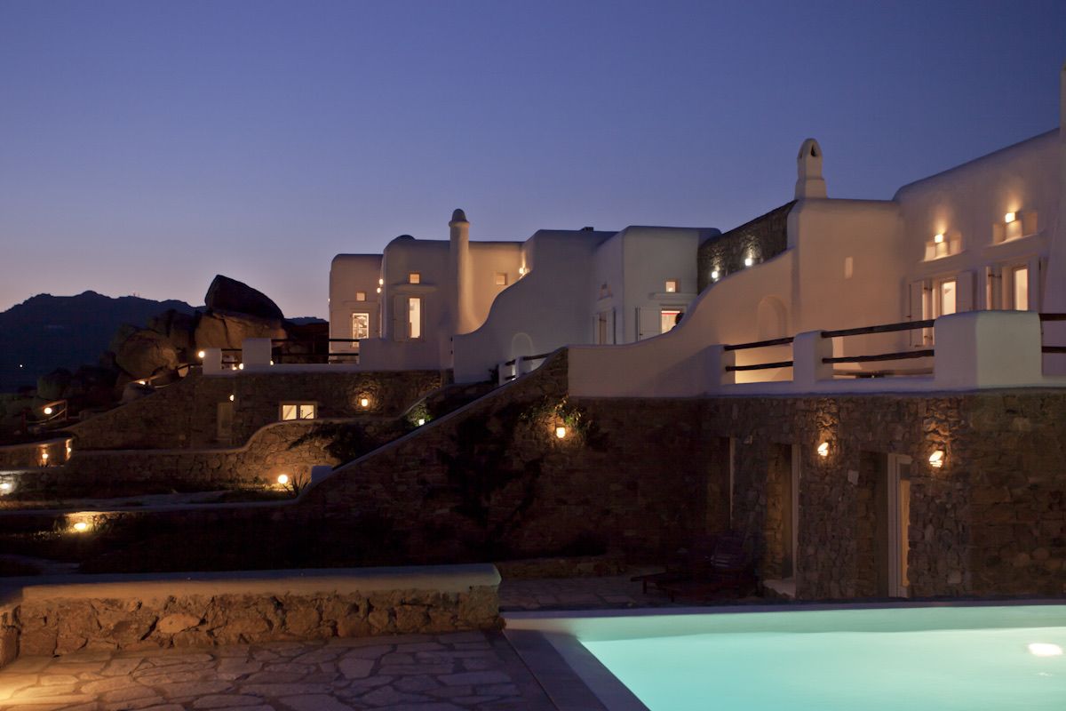 The villas lit up at night, seen across the pool